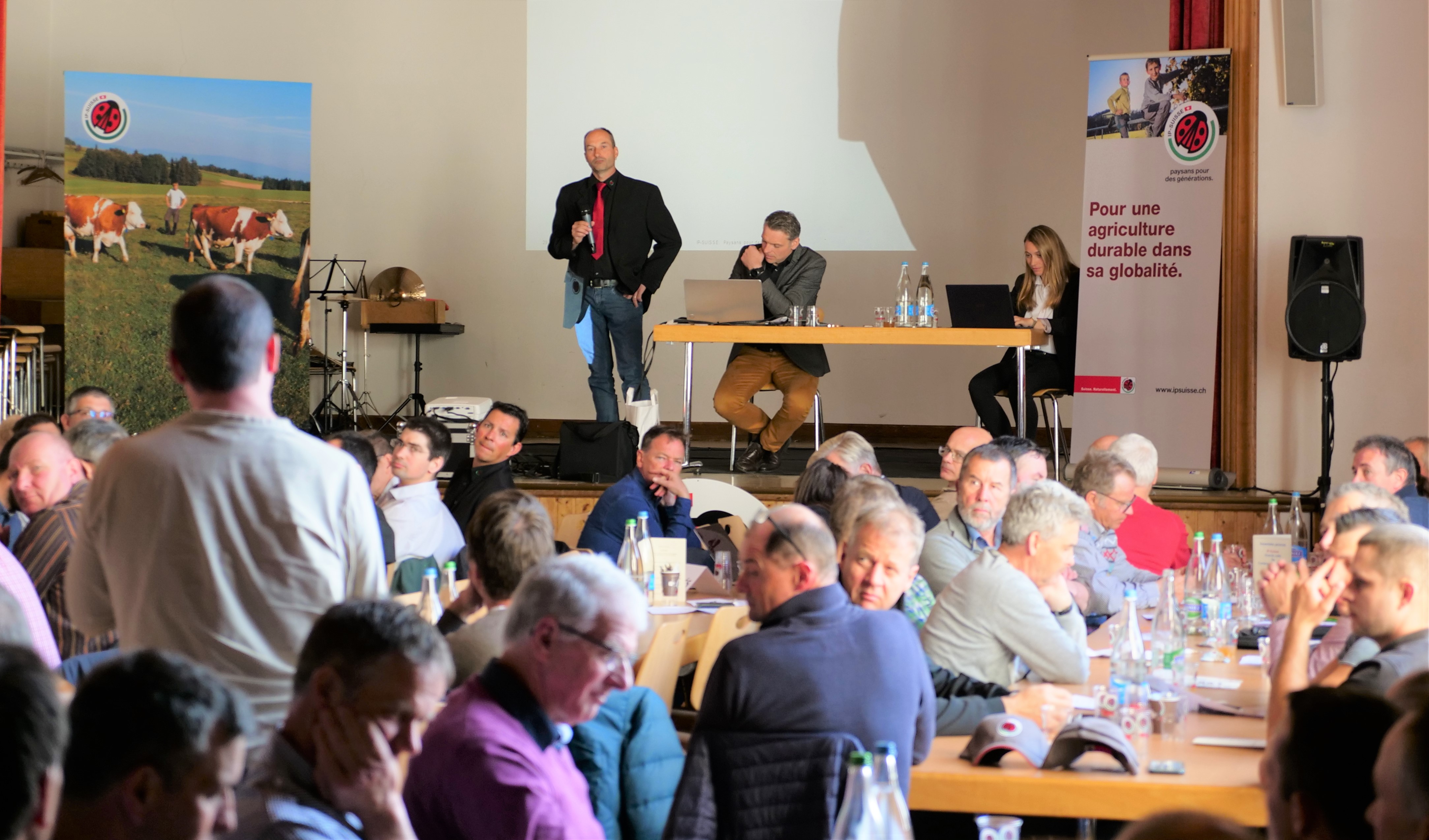 ©AGIR - Lle président Joël Scheidegger répond à une question. À sa droite: Jacques Demierre (gérant) et Joëlle Fuchs-Pittet (secretaire-comptable)